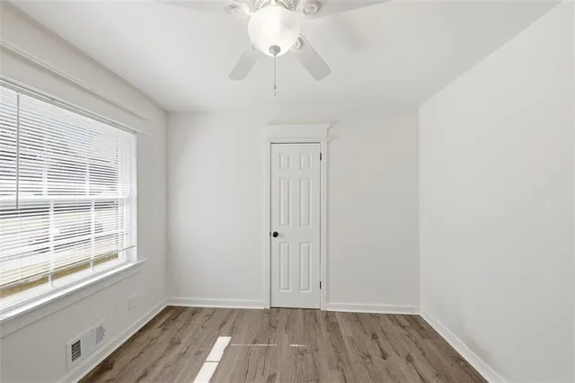 a view of room with window ceiling fan and wooden floor