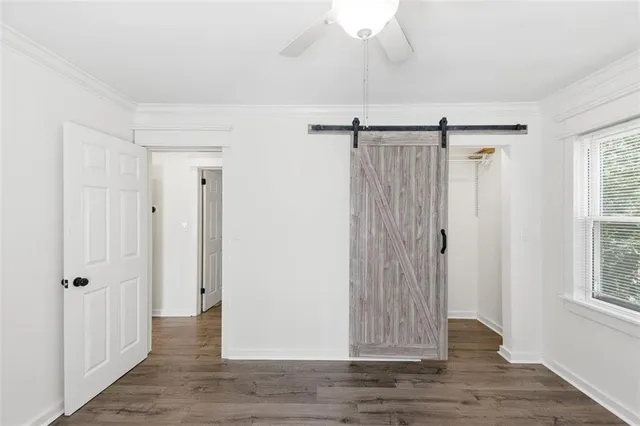 a view of a room with wooden floor fan and windows