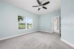 an empty room with a window and a fan