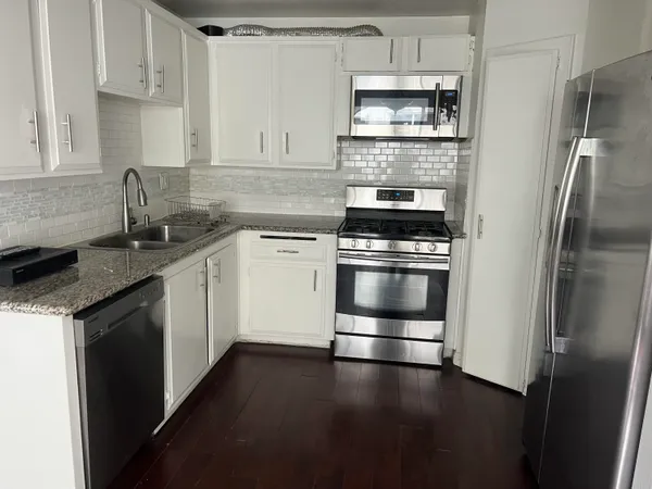 a view of an empty room with wooden floor and closet