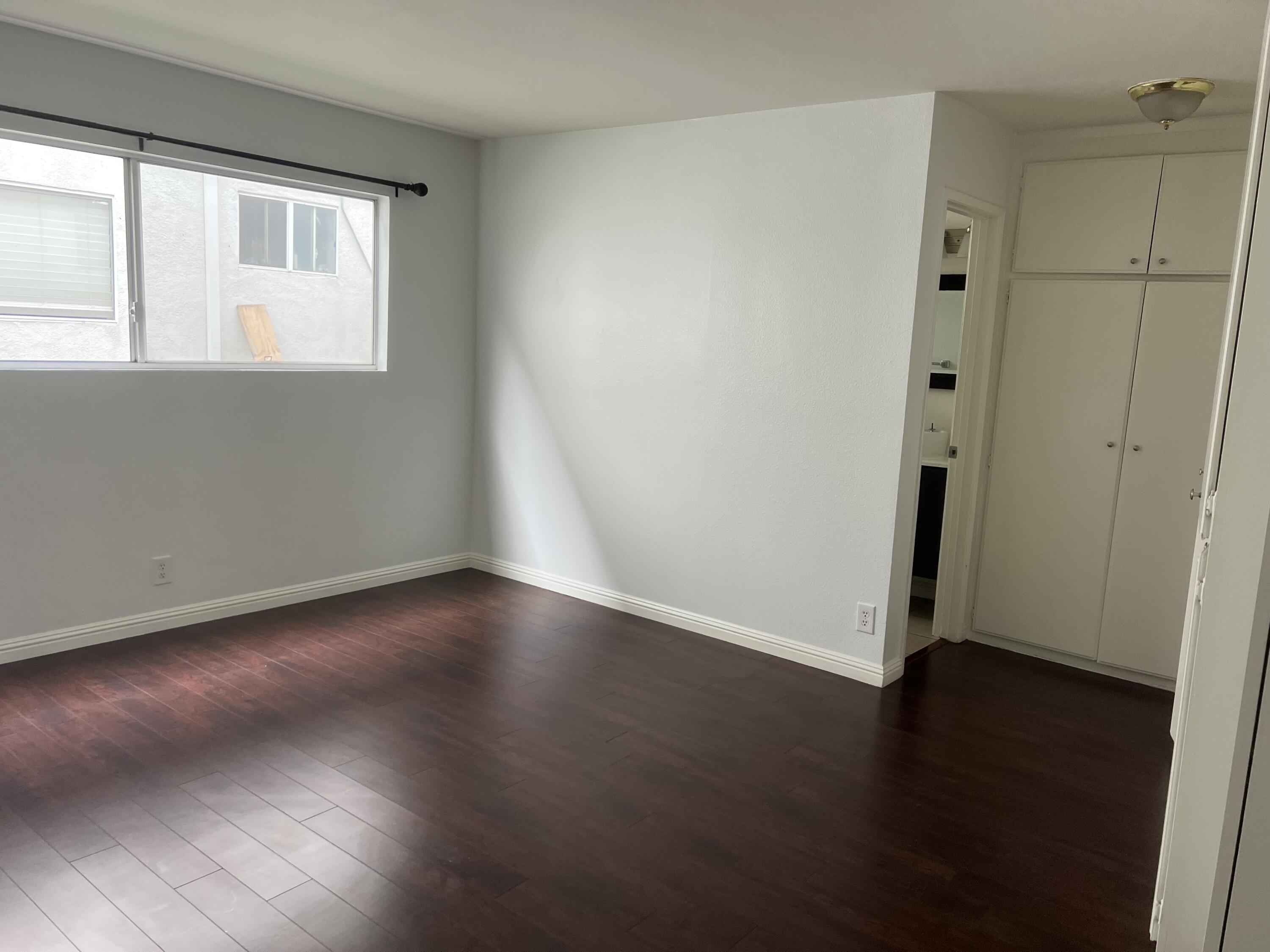 18555 Collins Street, Unit C8 Tarzana, CA 91356 - Photo 17 of 32 an empty room with wooden floor and windows