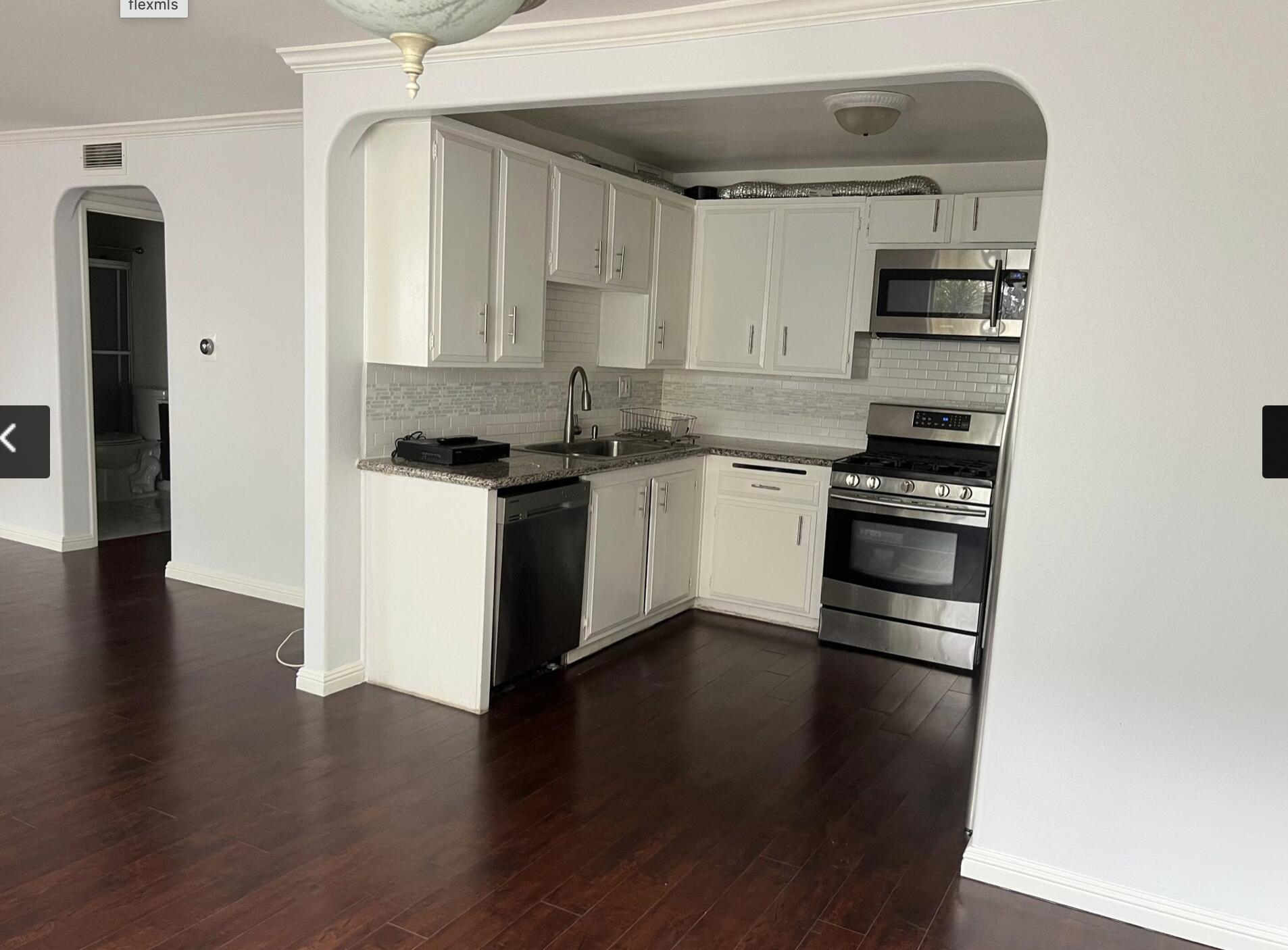 18555 Collins Street, Unit C8 Tarzana, CA 91356 - Photo 25 of 32 a kitchen with granite countertop a stove and a refrigerator