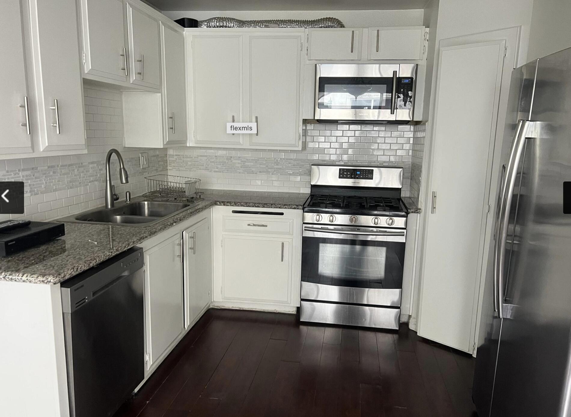 18555 Collins Street, Unit C8 Tarzana, CA 91356 - Photo 27 of 32 a kitchen with cabinets stainless steel appliances and wooden floor