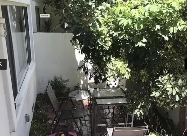 a backyard of a house with table and chairs