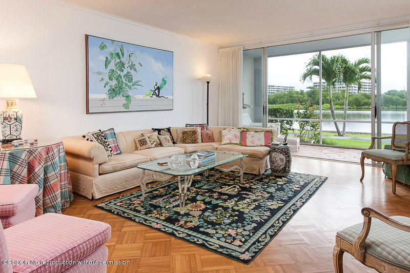 a living room with large couches a coffee table and a large window with garden view