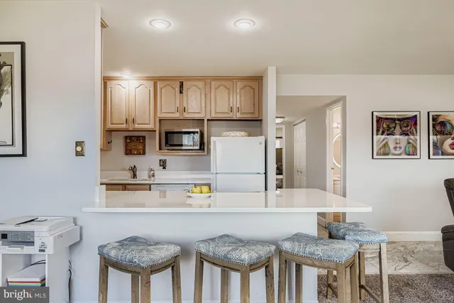a kitchen with stainless steel appliances granite countertop a stove a sink cabinets and a dining table