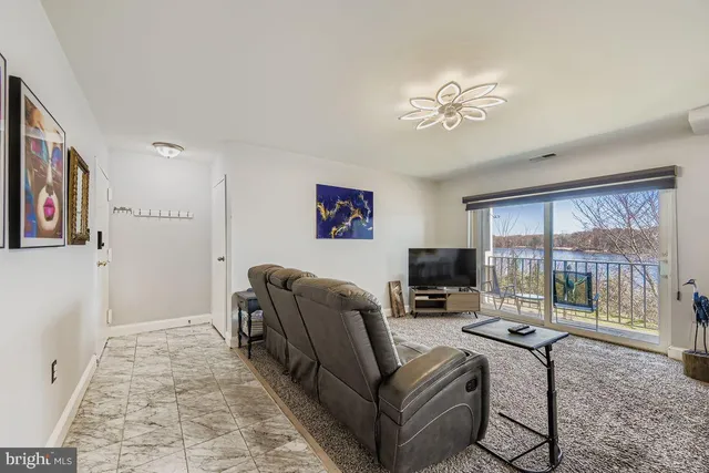 a living room with furniture a flat screen tv and a floor to ceiling window