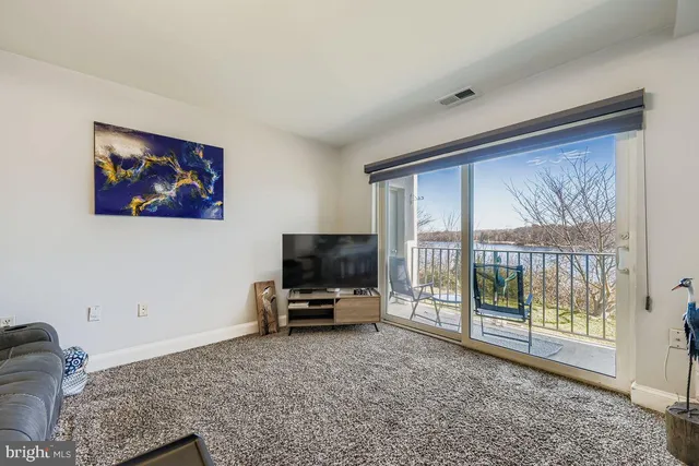 a living room with furniture a flat screen tv and a floor to ceiling window
