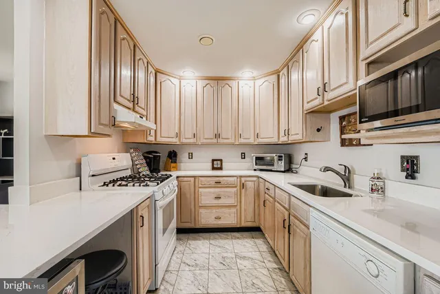 a kitchen with stainless steel appliances granite countertop a sink stove and cabinets