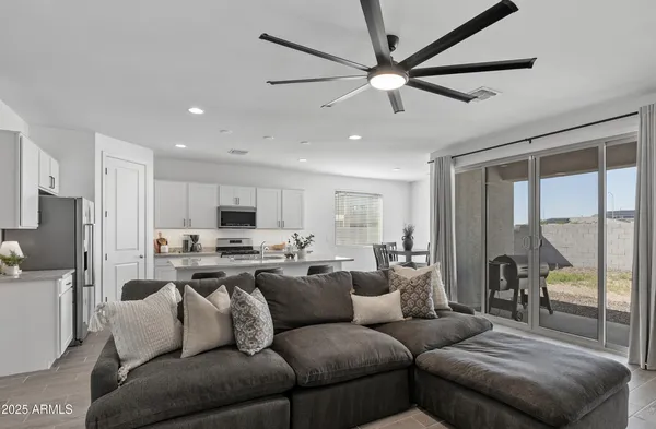 a living room with furniture kitchen view and a large window