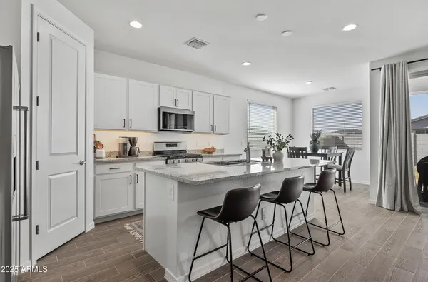 a kitchen with kitchen island granite countertop a sink cabinets and stainless steel appliances