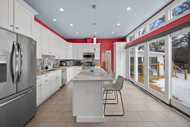 a kitchen with stainless steel appliances kitchen island granite countertop a refrigerator and a stove top oven