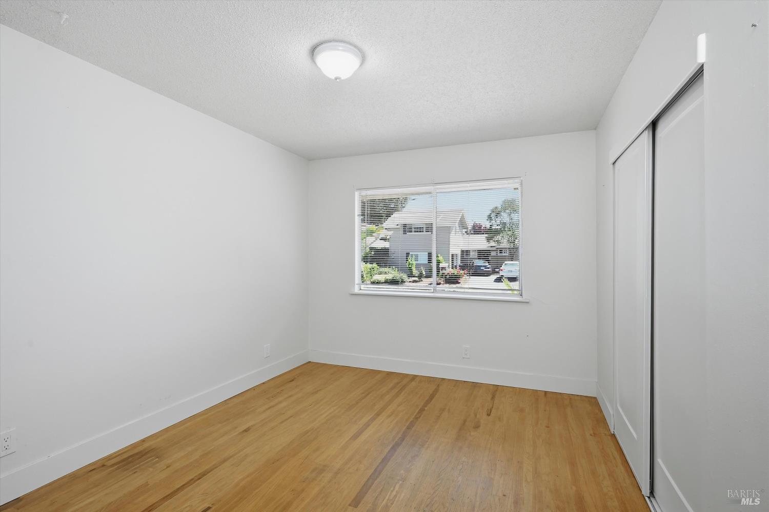 2537 Tamarisk Drive Santa Rosa, CA 95405 - Photo 15 of 25 an empty room with a window and wooden floor