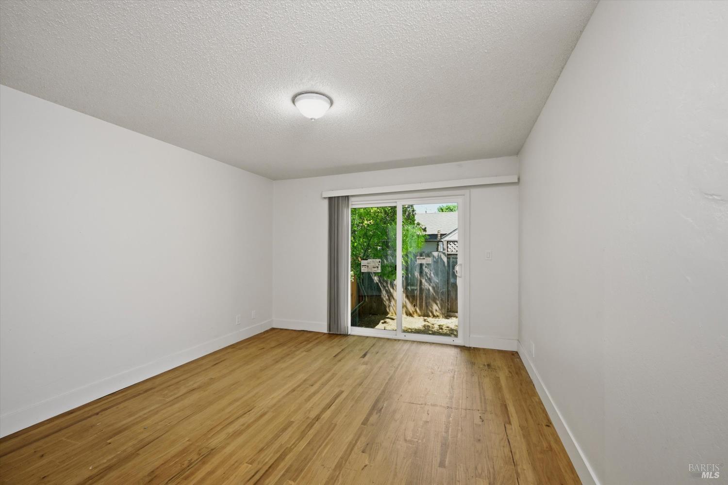 2537 Tamarisk Drive Santa Rosa, CA 95405 - Photo 17 of 25 wooden floor in an empty room with a window