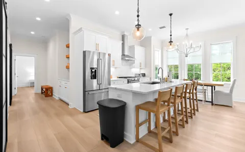 a kitchen with a table chairs sink and cabinets