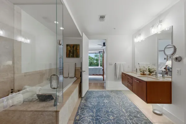 a large spacious bathroom with a tub sink and mirror