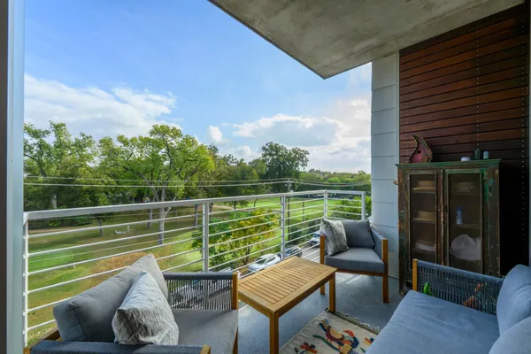 a view of a patio with couches chairs and a floor to ceiling window