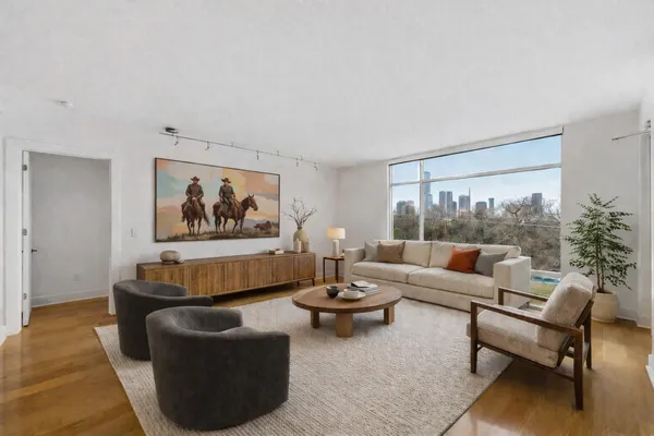 a living room with fireplace furniture and a large window