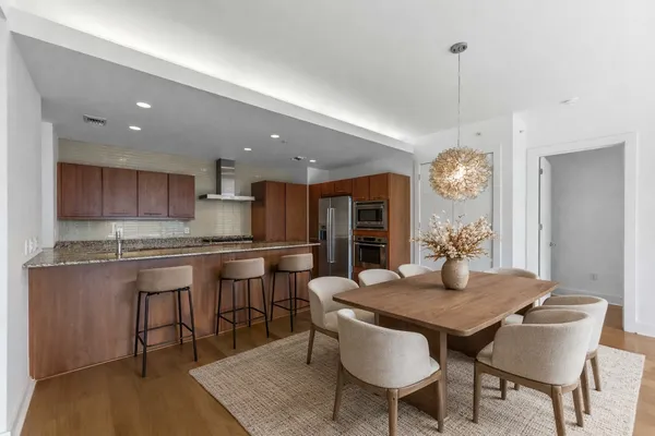 a kitchen with a dining table chairs and refrigerator