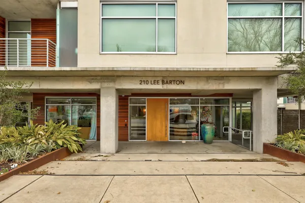 front view of a brick house with potted plants