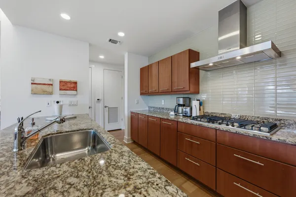 a kitchen with stainless steel appliances a sink a stove and cabinets