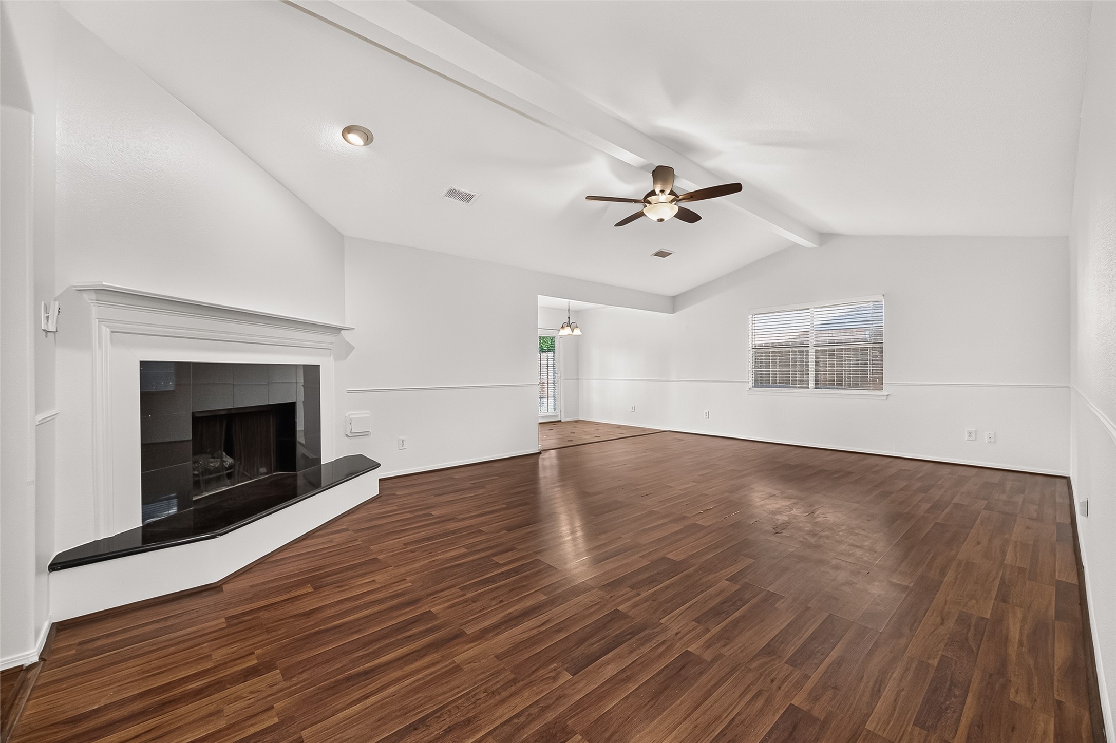 9322 Magnolia Ridge Drive Houston, TX 77070 - Photo 2 of 16 Bright, open living space freshly painted, vaulted ceilings, and warm wood-look flooring with a gas fireplace.
