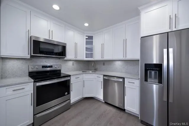 a kitchen with stainless steel appliances granite countertop a refrigerator stove a sink and microwave