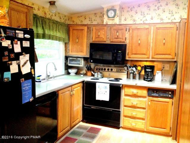 3113 Bear Road Bushkill, PA 18324 - Photo 5 of 38 a kitchen with stainless steel appliances kitchen island granite countertop a refrigerator and a stove top oven