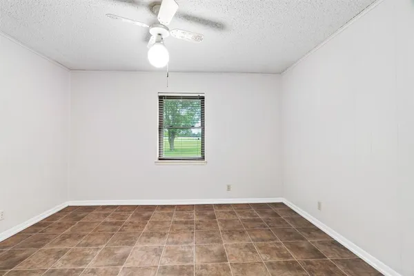 an empty room with a window and a fan