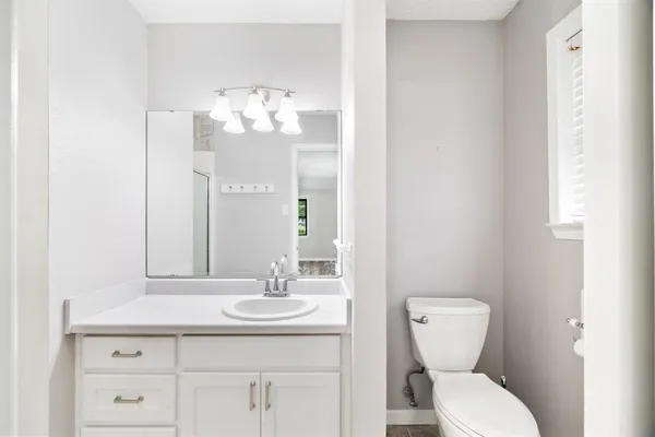 a bathroom with a toilet sink and mirror