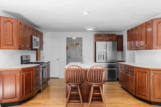 a kitchen with granite countertop wooden cabinets and stainless steel appliances