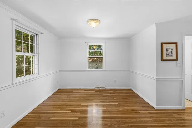 a view of empty room with window and wooden floor