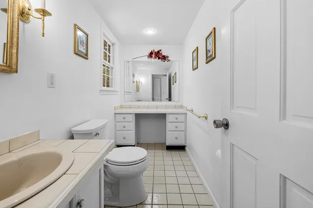 a bathroom with a sink a toilet and a mirror