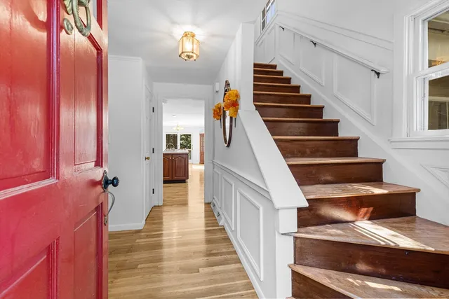 a view of staircase with lots of frames on wall and wooden floor
