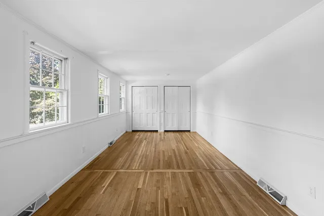 a view of a room with wooden floor and window