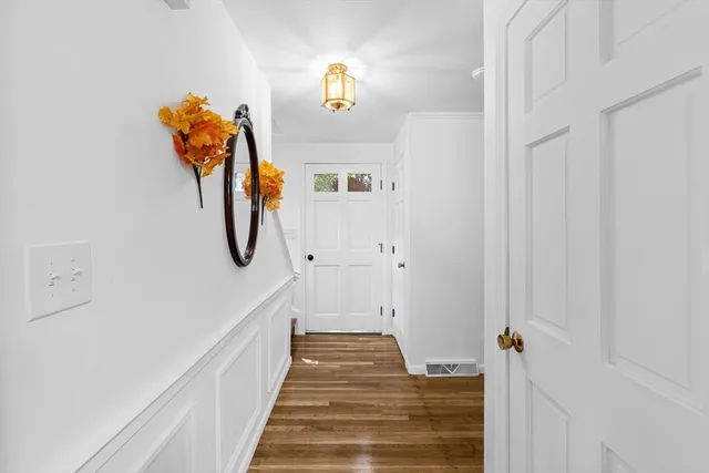 a view of a hallway with wooden floor and staircase