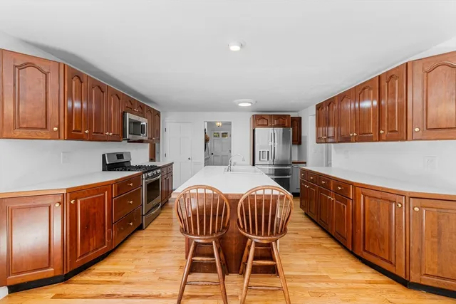 a kitchen with stainless steel appliances granite countertop wooden cabinets a stove top oven a sink and dishwasher