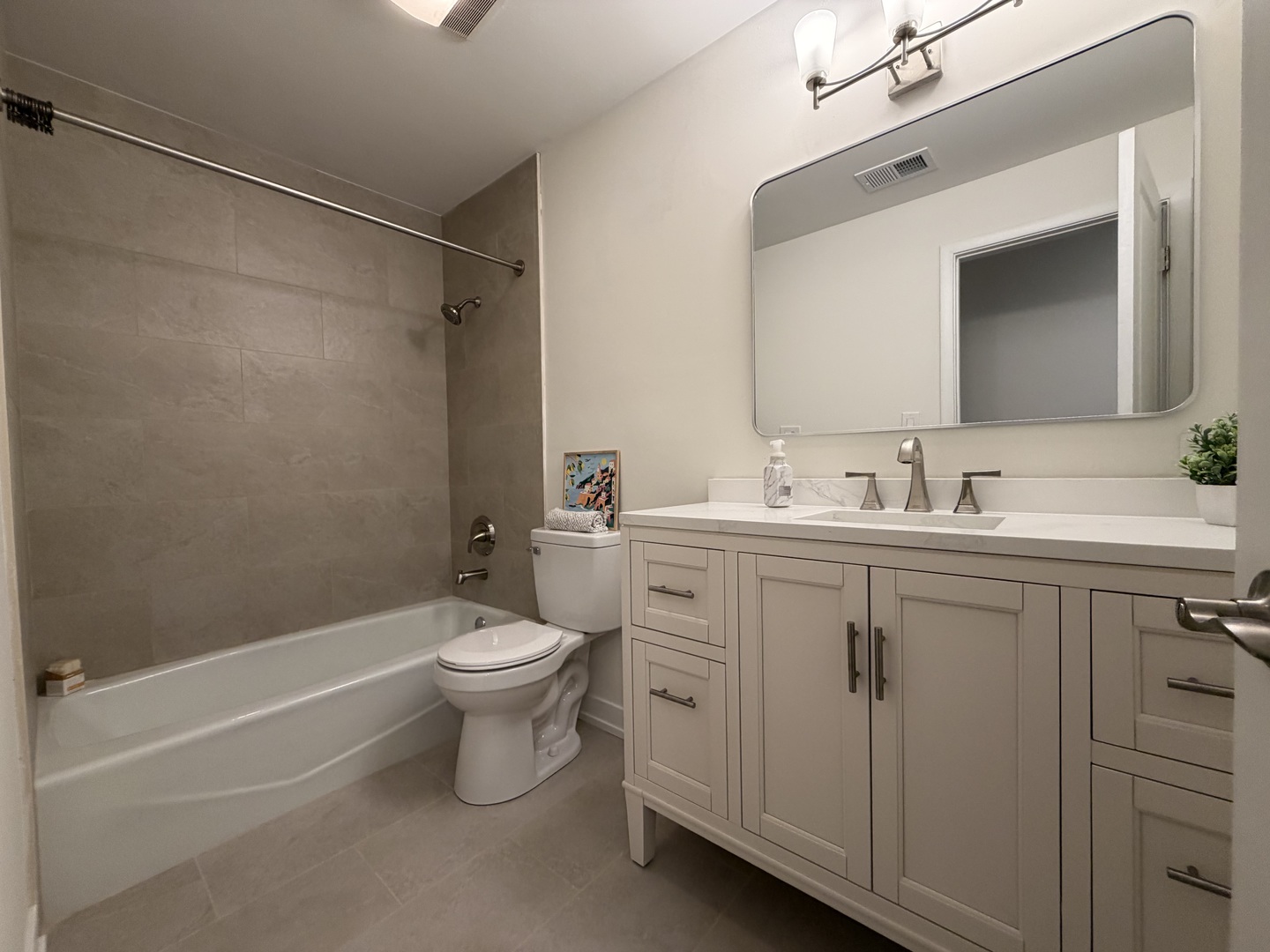 607 West Central Road, Unit A4 Mount Prospect, IL 60056 - Photo 6 of 13 a bathroom with a toilet a sink a mirror a bathtub and vanity