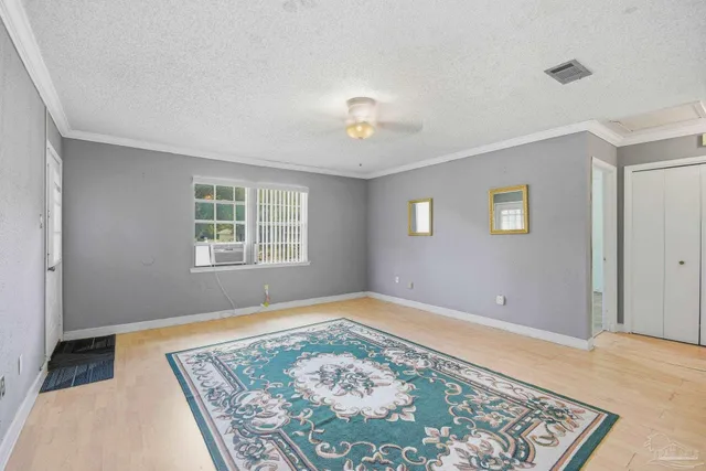 an empty room with ceiling fan and windows