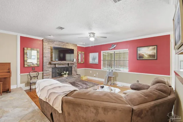 a living room with furniture a flat screen tv and a floor to ceiling window