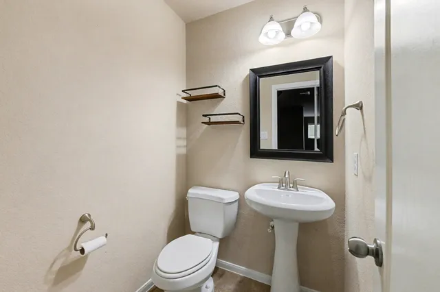 a bathroom with a toilet sink and mirror