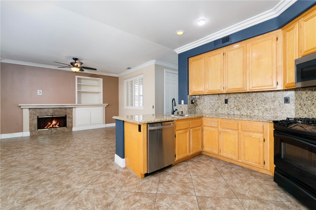 12206 Tunbridge Court Rancho Cucamonga, CA 91739 - Photo 15 of 34 a kitchen with stainless steel appliances granite countertop a stove a sink and a microwave