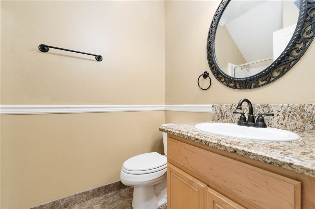 12206 Tunbridge Court Rancho Cucamonga, CA 91739 - Photo 23 of 34 a bathroom with a granite countertop sink a mirror and a toilet