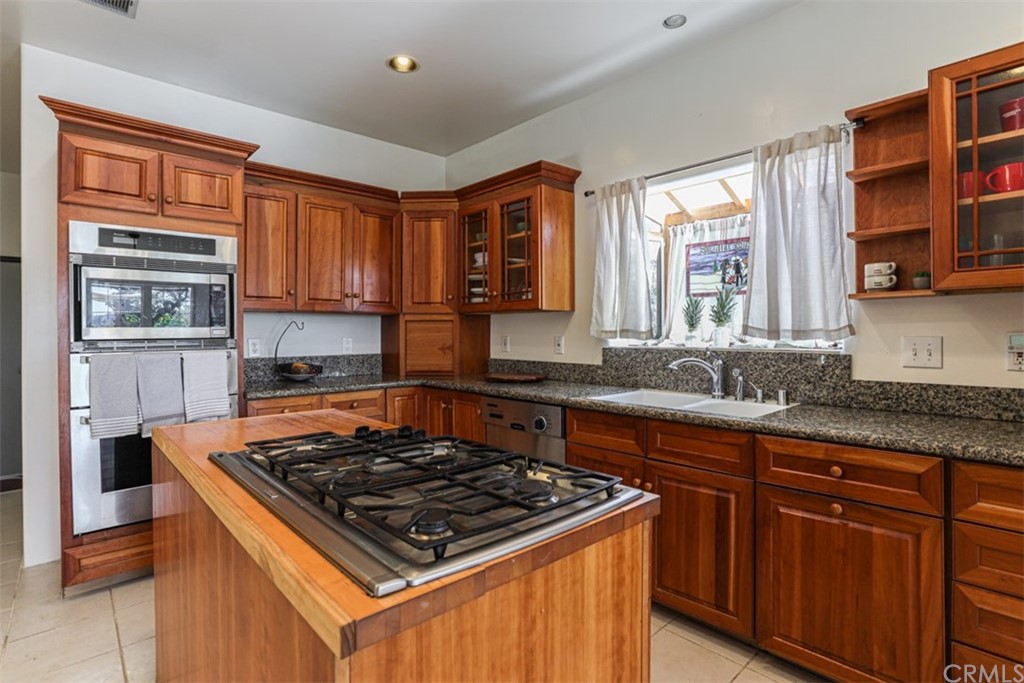 1608 Hill Drive Eagle Rock, CA 90041 - Photo 15 of 71 a kitchen with stainless steel appliances granite countertop wooden cabinets stove top oven and sink