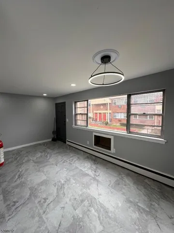 a view of empty room with wooden floor and windows