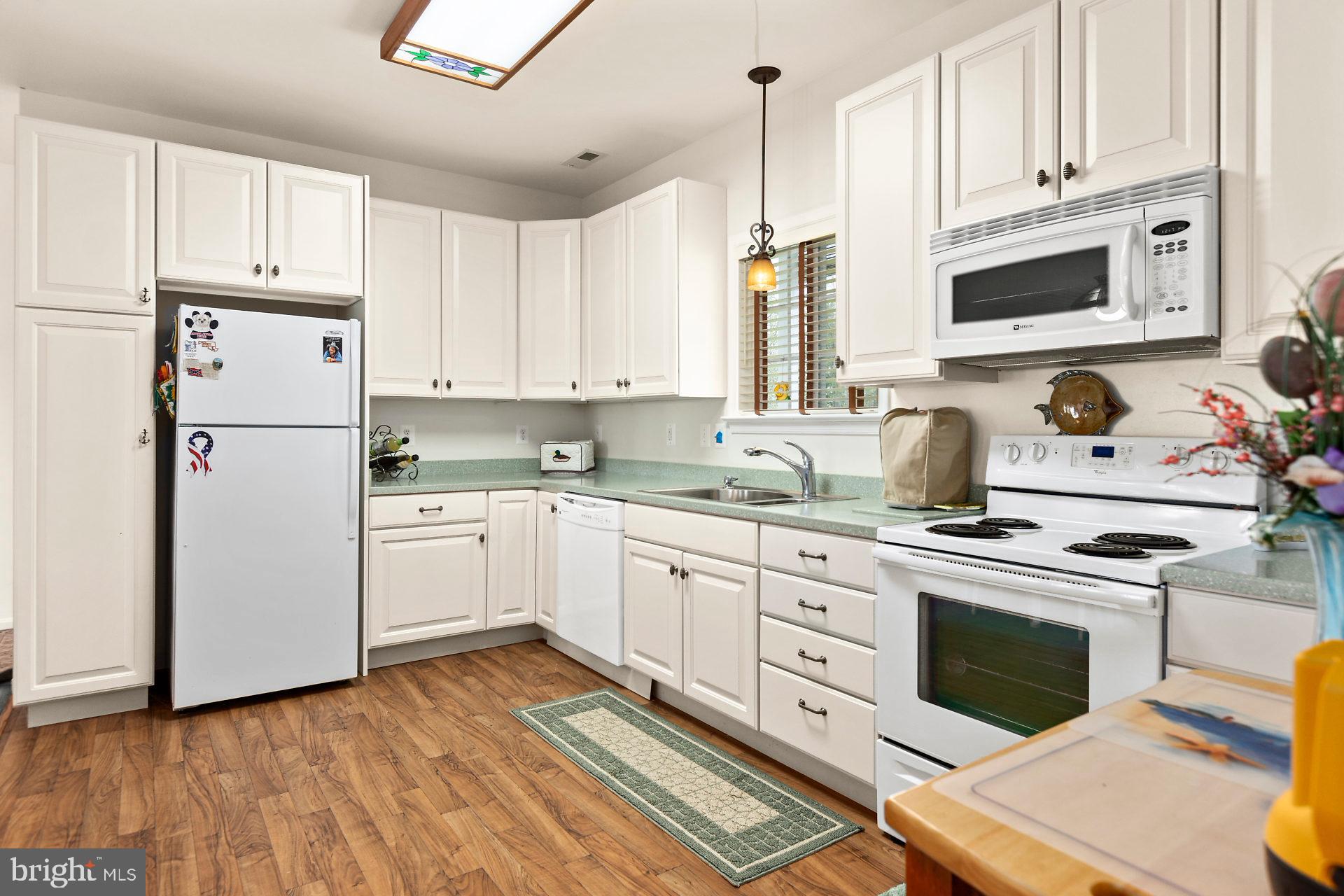 49898 Airedele Road Ridge, MD 20680 - Photo 10 of 30 a kitchen with granite countertop white cabinets and white appliances