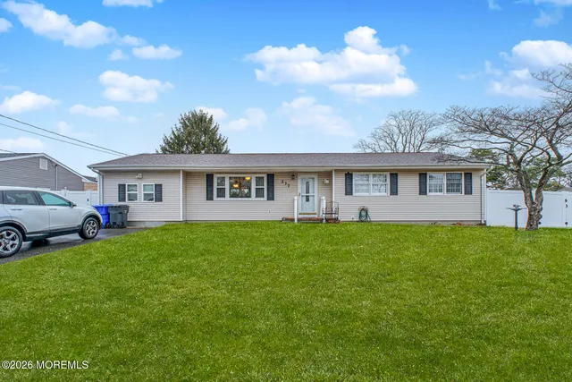 a view of a house with a big yard and large trees