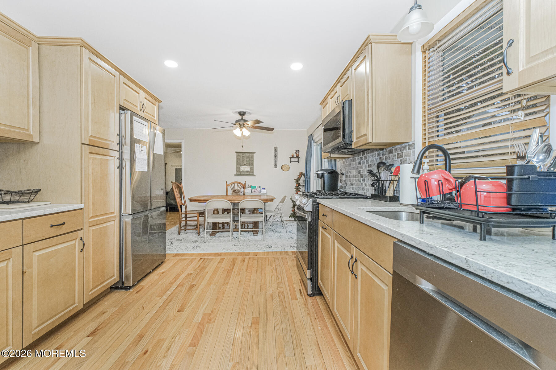 237 Pine Tree Drive Brick, NJ 08723 - Photo 12 of 24 a kitchen with stainless steel appliances granite countertop a refrigerator a sink dishwasher a stove and white countertops with wooden floor