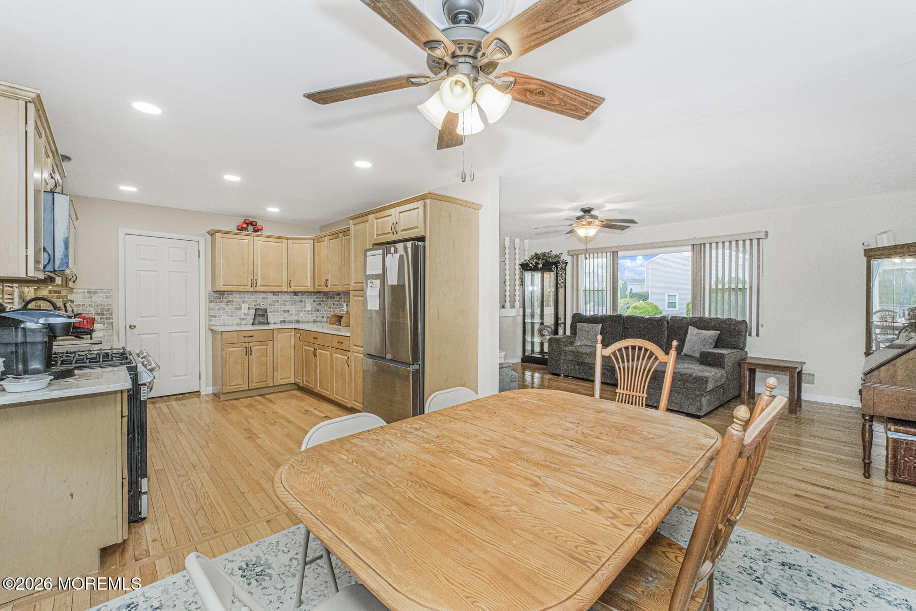 237 Pine Tree Drive Brick, NJ 08723 - Photo 18 of 24 a kitchen with stainless steel appliances kitchen island granite countertop a refrigerator a stove a sink dishwasher with a dining table and chairs with wooden floor