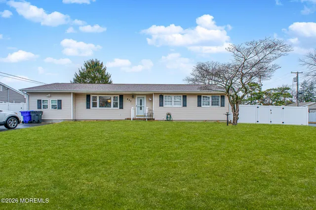 a view of a yard in front of a house with large trees